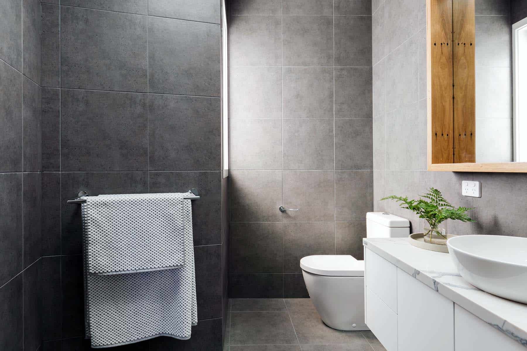 Charcoal grey bathroom with marble benctop and wood mirror